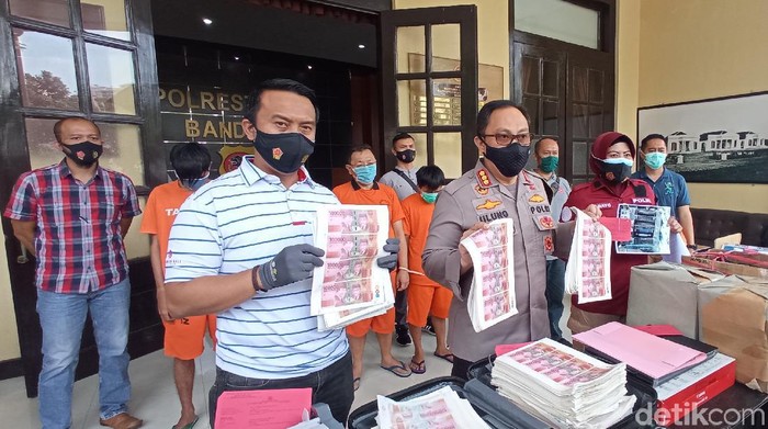 Polisi meringkus komplotan pencetak uang palsu di Bandung. Lembaran uang hasil cetakan sejumlah Rp 800 juta disita polisi.