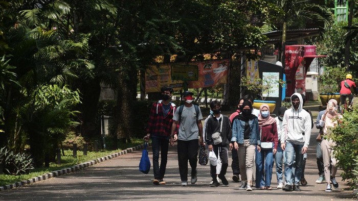 Pengunjung berposse di kandang Gajah sumatera saat mengisi waktu libur di Taman Margasatwa Ragunan, Jakarta