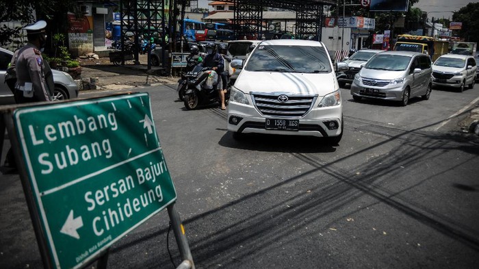 Anggota kepolisian mengalihkan jalur menuju kawasan wisata Lembang di Jalan Setiabudi, Bandung, Jawa Barat, Kamis (29/10/2020). Pada cuti bersama serta libur panjang Maulid Nabi Muhammad SAW hari kedua, jalur wisata menuju Lembang dipadati kendaraan wisatawan, dan kepolisian memberlakukan pengalihan arus untuk mengurai kemacetan. ANTARA FOTO/Raisan Al Farisi/aww.