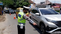Anggota kepolisian mengatur arus lalu lintas menuju kawasan wisata Lembang di Jalan Setiabudi, Bandung, Jawa Barat. Bahkan jalan tersebut diberlakukan rekayasa lalu lintas atau buka tutup.