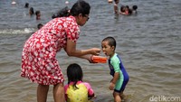 Anak-anak tersebut tampak bermain air dan pasir serta berenang di Pantai Ancol.
