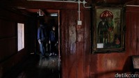 Sebuah lukisan tampak menggantung di salah satu sisi dinding di dalam rumah tersebut.
