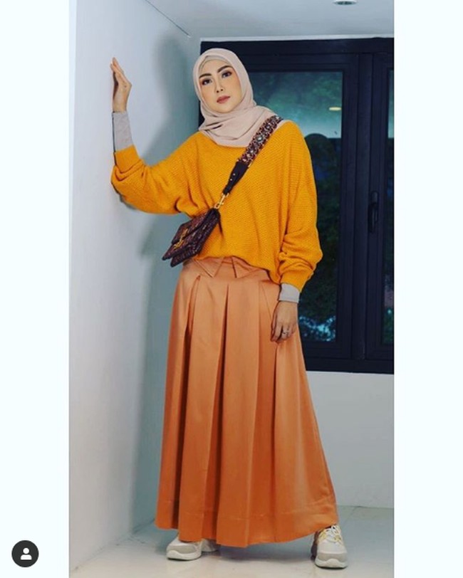 Pada penampilan lainnya, Fenita Arie tampil matching dengan atasan kuning dan rok oranye kecokelatan. Dia membawa tas dari brand Prancis, Christian Dior. Foto: Instagram @fenitarie