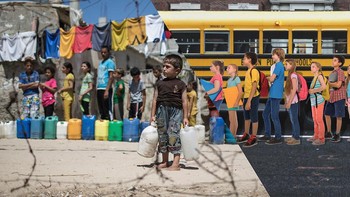 Anak-anak Palestina menunggu untuk mengisi jerigen dan botol dengan air minum dari keran umum di kamp pengungsi Dair Al Balah di Jalur Gaza tengah pada tahun 2014. Foto: Uğur Gallenkuş