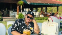 Berlibur ke Bali, sudah pasti Igun tak melewatkan momen wisata kuliner. Terlihat ia sedang menikmati es kelapa hijau langsung dari batoknya dan aneka gorengan. Foto: Instagram @ivan_gunawan
