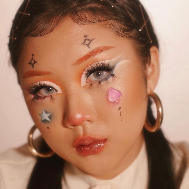 Beginilah penampilan makeup Halloween ala @nicolesmakeup_. Ia membuat bentuk waru dan bintang di pipinya. Plus eyeshadow yang dibuat cut crease.  Foto: Instagram