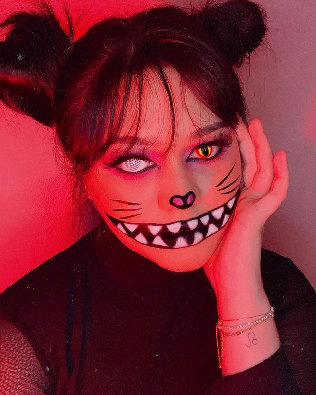 Beauty influencer Sarah Ayu membuat makeup kucing yang seram sekaligus imut. Ditambah dengan face painting efek gigi, makeup @sarahayuh_ terbilang epic.  Foto: Instagram