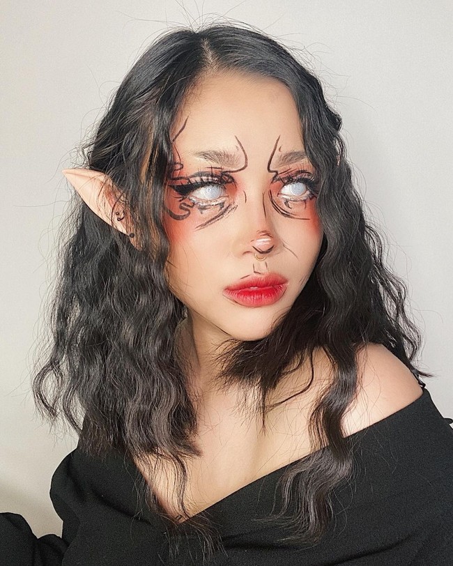 Beauty influencer dan vlogger Cindercella tidak ketinggalan dalam membuat tampilan untuk Halloween. Cella membuat makeup ala Elf. Bermodalkan aksesori telinga dan lensa kontak putih, tampilannya jadi seram. Untuk face painting, Cindercella memanfaatkan eyeliner yang dicoretkan di beberapa bagian wajahnya.  Foto: Instagram