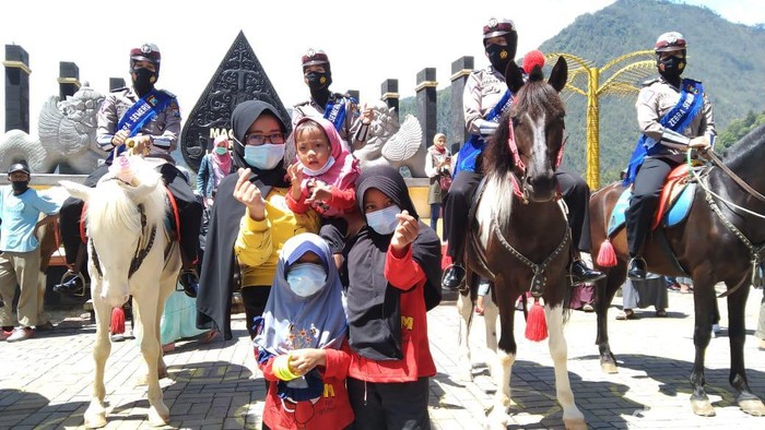 Pengunjung wisata Telaga Sarangan meningkat saat libur panjang. Satlantas Polres Magetan menggelar Operasi Zebra Semeru 2020, sambil memberikan cokelat dan masker kepada pengunjung.