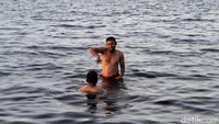 Dua orang pengunjung sedang asyik menikmati Pantai Marunda.