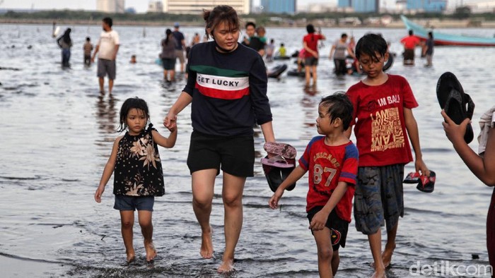 Warga bermain di kawasan Pantai Marunda, Jakarta Utara, Kamis (29/10/2020). Menurut ketenangan warga, Pantai Marunda merupakan wisata alternatif yang murah meriah untuk menghabiskan waktu libur panjang bersama keluarga.