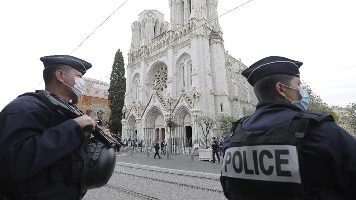 Police officers stand guard near Notre Dame church in Nice, southern France, Thursday, Oct. 29, 2020. An attacker armed with a knife killed at least three people at a church in the Mediterranean city of Nice, prompting the prime minister to announce that France was raising its security alert status to the highest level. It was the third attack in two months in France amid a growing furor in the Muslim world over caricatures of the Prophet Muhammad that were re-published by the satirical newspaper Charlie Hebdo. (Eric Gaillard/Pool via AP)