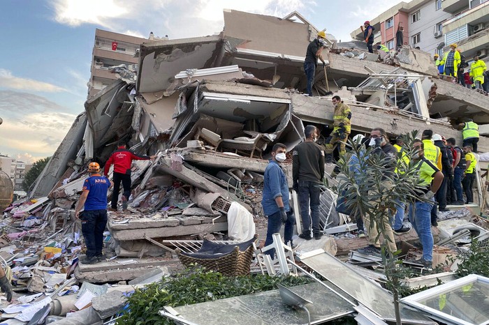 Rescue workers and local people try to reach residents trapped in the debris of a collapsed building, in Izmir, Turkey, Friday, Oct. 30, 2020, after a strong earthquake in the Aegean Sea has shaken Turkey and Greece. Turkeys Disaster and Emergency Management Presidency said Fridays earthquake was centered in the Aegean at a depth of 16,5 kilometers (10.3 miles) and registered at a 6.6 magnitude.(AP Photo/Ismail Gokmen)