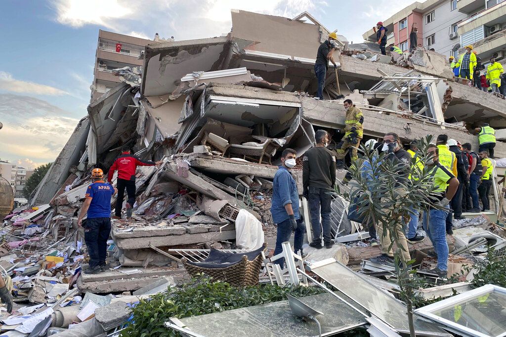 Rescue workers and local people try to reach residents trapped in the debris of a collapsed building, in Izmir, Turkey, Friday, Oct. 30, 2020, after a strong earthquake in the Aegean Sea has shaken Turkey and Greece. Turkey's Disaster and Emergency Management Presidency said Friday's earthquake was centered in the Aegean at a depth of 16,5 kilometers (10.3 miles) and registered at a 6.6 magnitude.(AP Photo/Ismail Gokmen)