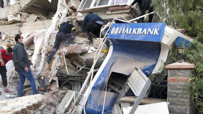 Rescue workers and local people try to reach residents trapped in the debris of a collapsed building, in Izmir, Turkey, Friday, Oct. 30, 2020, after a strong earthquake in the Aegean Sea has shaken Turkey and Greece. Turkeys Disaster and Emergency Management Presidency said Fridays earthquake was centered in the Aegean at a depth of 16,5 kilometers (10.3 miles) and registered at a 6.6 magnitude.(AP Photo/Ismail Gokmen)