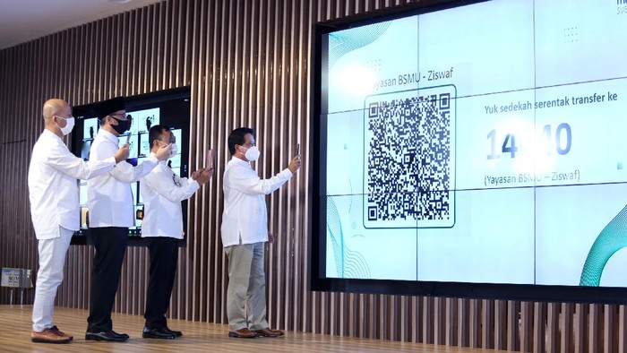 Direktur Utama Bank Syariah Mandiri Hery Gunardi (kanan), bersama Komisaris Independen Bank Syariah Mandiri Suyanto (kedua kanan), Ketua Dewan Pengawas Syariah Mohamad Hidayat (ketiga kanan), Direktur Finance, Strategy dan Treasury Ade Cahyo Nugroho (kiri) memindai kode batang untuk sedekah serentak bersama seluruh jajaran Direksi, Komisaris, DPS dan pegawai di seluruh Indonesia secara daring di Jakarta, Minggu (1/11/2020). Dalam rangka milad ke-21 tahun Bank Syariah Mandiri menggelar program berbagi dan peduli untuk masyarakat di Indonesia bernilai Rp24,7 miliar dan menyentuh lebih dari 30 ribu penerima manfaat di Indonesia.