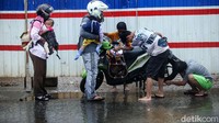 Pengendara menepikan motornya yang mogok usai menerobos banjir di kolong tol JORR, Bekasi, Minggu (1/11/2020).