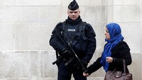 Seorang polisi Prancis berjaga-jaga saat seorang wanita muslim meninggalkan Masjid Agung Paris (Grande mosquee de Paris) setelah salat Jumat pada 20 November 2015. Thierry Chesnot/Getty Images.