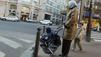 Seorang ibu dan anaknya melintas di jalan kota Paris. Pascal Le Segretain/Getty Images.