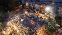Alat berat juga dikerahkan untuk mencari korban yang tertimbun reruntuhan bangunan di Izmir, Turki. Burak Kara/Getty Images.