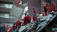 Alat berat menyingkirkan puing-puing bangunan untuk mempermudah tim SAR melakukan pencarian korban gempa. Burak Kara/Getty Images.