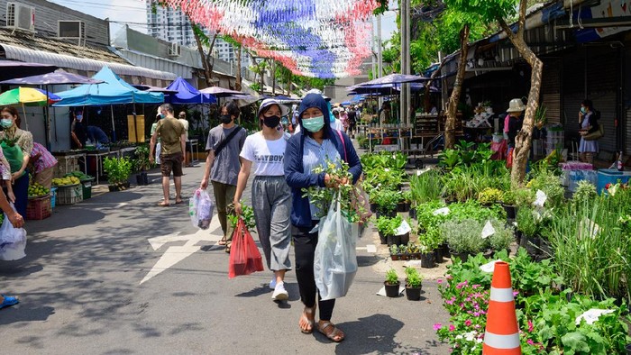 Bangkok, Thailand - May 13, 2020 : Crowd of people wearing surgical mask and walking at Chatuchak Plant Market.