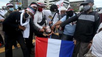 Dengan mengenakan jas dan topeng presiden Prancis, peserta aksi tersebut keliling untuk berfoto bersama massa aksi.
