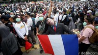 Seorang peserta aksi membuat teatrikal presiden Prancis yang diikat dan dibawa keliling di tengah aksi bela nabi yang digelar di area Kedubes Prancis, Jakarta, Selasa (2/11/2020).