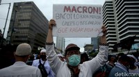 Dalam aksi tersebut, massa membawa spanduk yang bertuliskan kecaman ke Presiden Prancis, Emmanuel Macron.