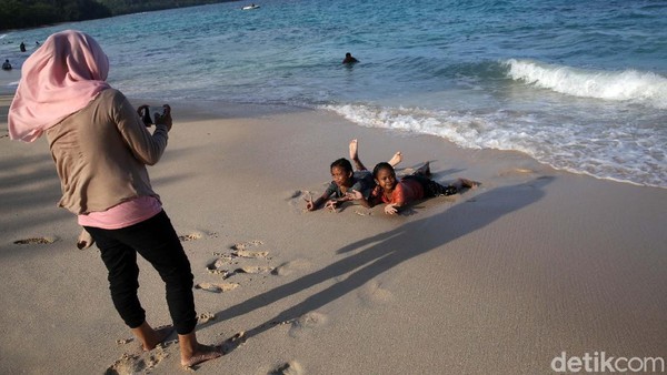Anak-anak bermain di pasir putih Pantai Paal Likupang.