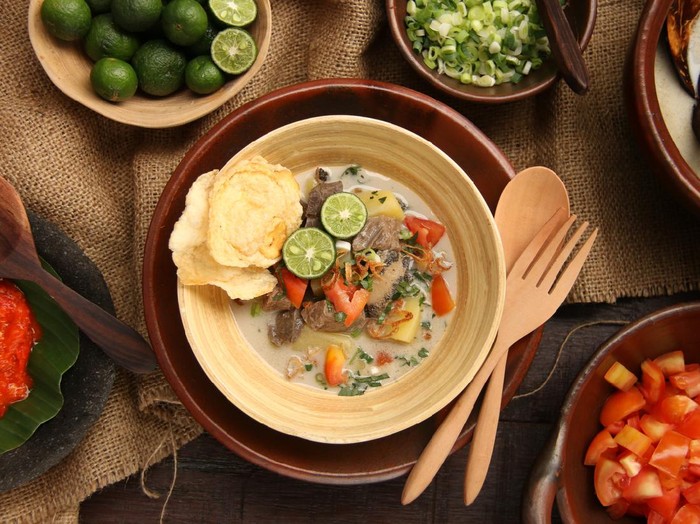Soto Betawi Soto Betawi, the popular traditional beef and offal soup from Betawi, Jakarta. The soup dish has been pre-plated in a bamboo bowl with an earthenware plate as the underliner. A pair of wooden spoon and fork is placed on the plate. The soup is surrounded with the broth and condiments.