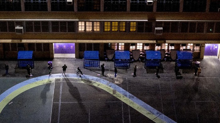 People line up on a playground before the door of a polling place opened at an elementary school in the Manhattan borough in New York Tuesday, Nov. 3, 2020. (AP Photo/Craig Ruttle)