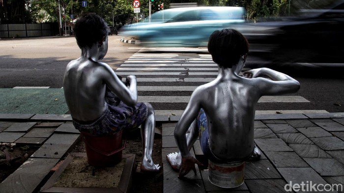 Rido (10) dan Putra (10) mengamen sebagai manusia silver untuk membantu beban ekonomi orang tua mereka yang terdampak pandemi COVID-19.