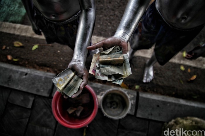 Rido (10) dan Putra (10) mengamen sebagai manusia silver untuk membantu beban ekonomi orang tua mereka yang terdampak pandemi COVID-19.