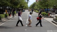Warga hingga wisatawan bebas lalu lalang di tengah Jalan Malioboro.
