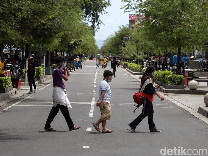 Sejumlah pengunjung berfoto ditengah jalan Malioboro saat uji coba management rekayasa lalu lintas kawasan pedestrian Malioboro, Yogyakarta, Selasa (3/11/2020). Pembatasan kendaraan bermotor yang masuk Jalan Malioboro membuat pengunjung leluasa menikmati kawasan pedestrian malioboro