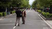 Wisatawan asyik berfoto-foto di tengah Jalan Malioboro.