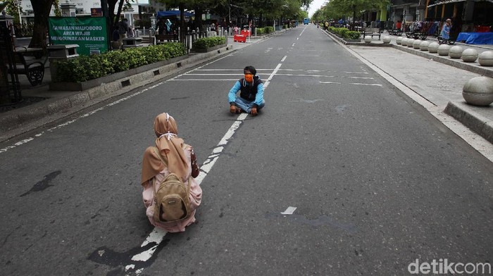 Menikmati Malioboro yang Sepi Kendaraan Bermotor Sejumlah pengunjung berfoto ditengah jalan Malioboro saat uji coba management rekayasa lalu lintas kawasan pedestrian Malioboro, Yogyakarta, Selasa (3/11/2020). Pembatasan kendaraan bermotor yang masuk Jalan Malioboro membuat pengunjung leluasa menikmati kawasan pedestrian malioboro