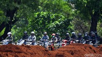 Iring-iringan kendaraan bermotor melintas di samping proyek pelebaran flyover.