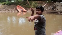Sauzah belajar mengoperasikan perahu eretan dari kakeknya.