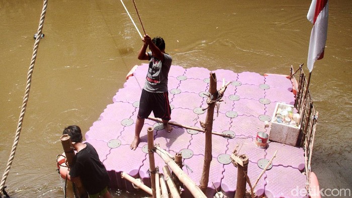 Perahu eretan tetap eksis menyeberangkan warga di Sungai Ciliwung, Jakarta, Selasa (3/11). Kali ini perahu eretan itu 'dinahkodai' Muhammad Sauzah Putra Rohman yang masih berusia 11 tahun.