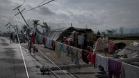 Tampak tiang listrik yang ambruk akibat Topan Goni dimanfaatkan para warga untuk menjemur baju mereka yang terendam banjir. Photo by Jes Aznar/Getty Images  