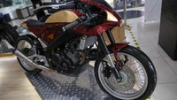 Alumunium swing arm diganti dengan handmade arm besutan Studi Motor berbahan plat hollow dengan ketebalan 2.5 mm dan 5 cm lebih panjang dari aslinya. Sedangkan tromolnya menggunakan hasil kustom berbahan duralium.  Tampilan klimis juga terlihat dari pemilihan warna merah candy bercampur kelir emas dengan efek basah mengkilap. Foto: Agung Pambudi