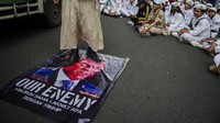 Massa membawa poster Macron berkepala monster yang diinjak-injak oleh mereka. ANTARA FOTO/Novrian Arbi