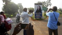 Papan reklame yang menampilkan calon wakil presiden dari partai demokratik AS Sen. Kamala Harris di sebuah persimpangan di desa Thulasendrapuram, India, juga menarik perhatian warga sekitar. AP Photo/Aijaz Rahi  