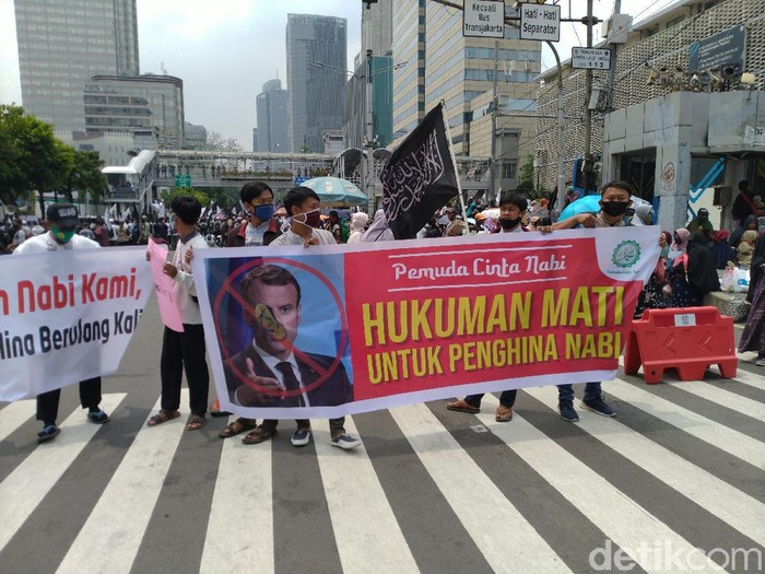Massa aksi bela Nabi membawa spanduk kecaman untuk Presiden Prancis Emmanuel Macron.