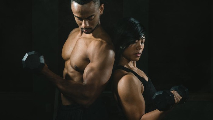 olahraga fitness Young African American Couple Lifting Weights Together In Gym