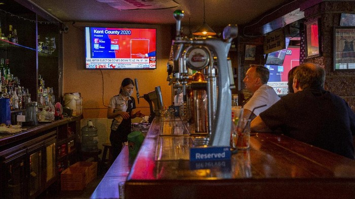 A group of U.S. Democrats supporters gather at a roadhouse restaurant to view U.S. media coverage of the U.S. presidential election in Bangkok, Thailand, Wednesday, Nov. 4, 2020. (AP Photo/Gemunu Amarasinghe)