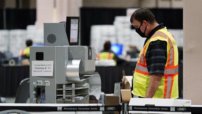 A Philadelphia election worker scans ballots for the 2020 general election in the United States at the Pennsylvania Convention Center, Tuesday, Nov. 3, 2020, in Philadelphia. (AP Photo/Matt Slocum)