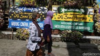 Karangan bunga tanda duka cita berjejer di jalan menuju rumah duka.